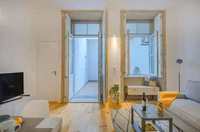 a living room with a bed and a flat screen tv at Santa Catarina Experience in Porto in Porto