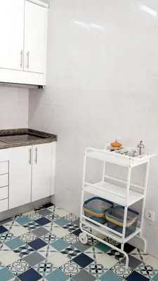 a kitchen with white cabinets and a blue and white tile floor at Gaia Central Apartment in Vila Nova de Gaia