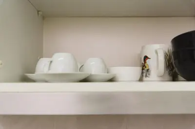 a shelf with white cups and bowls on it at Gaia Central Apartment in Vila Nova de Gaia
