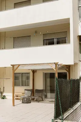 a building with a patio with chairs and a fence at Gaia Central Apartment in Vila Nova de Gaia