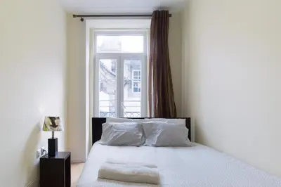 a bedroom with a white bed with a window at Porto Belomonte Flats - T2 in Porto
