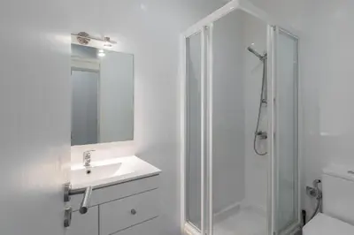 a white bathroom with a sink and a shower at Porto Belomonte Flats - T2 in Porto