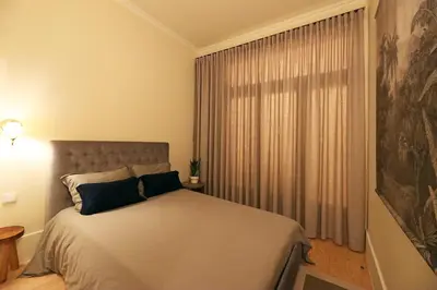 a bedroom with a bed and a large window at FLH Almada Cozy Apartment with View in Porto