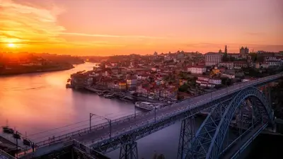a bridge over a river with a city at sunset at Porto City Hotel in Porto