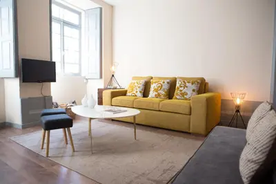 a living room with a yellow couch and a table at RIBEIRA CHARMING APARTMENTS in Porto