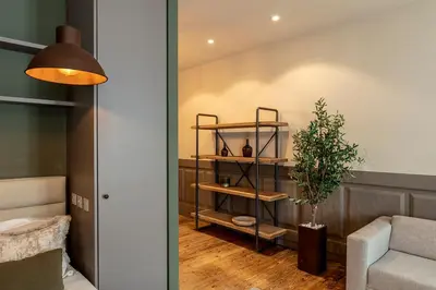 a room with a shelf with a plant and a couch at Olive Nature – Tourism Apartments in Porto
