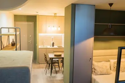 a room with a bed and a table and a kitchen at Olive Nature – Tourism Apartments in Porto