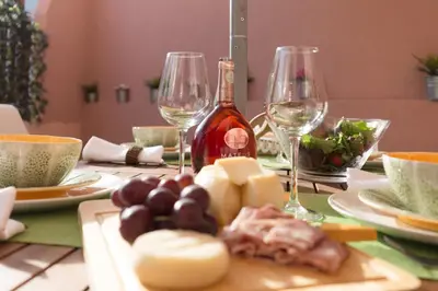 a table with a bottle of wine and a plate of food at Alves da Veiga Apartments in Porto