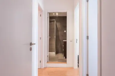 a bathroom with a walk in shower next to a door at Alves da Veiga Apartments in Porto