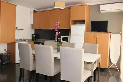 a kitchen with a table and chairs and a refrigerator at Studios Porto Solar in Porto