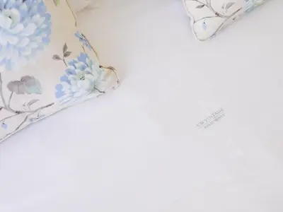 a bed with a pillow with blue flowers on it at CM VINTAGE Apartments - Breiner in Porto