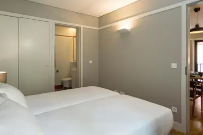 a bedroom with a white bed and a table at Porto Republica Apartments in Porto