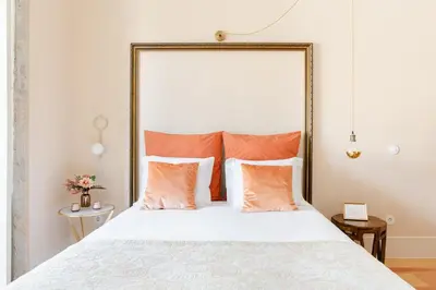 a bedroom with a large bed with orange pillows at Get a Golden and Flower Flat in Porto