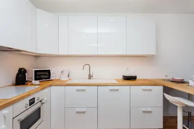 a white kitchen with white cabinets and a sink at Sancha Apartment - in the Centre near the Aliados in Porto