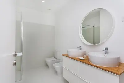 a bathroom with two sinks and a mirror at Sancha Apartment - in the Centre near the Aliados in Porto