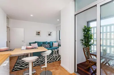 a kitchen and living room with a table and chairs at Sancha Apartment - in the Centre near the Aliados in Porto