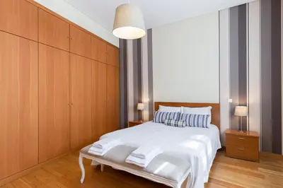 a bedroom with a white bed and wooden cabinets at OPO 52 in Porto