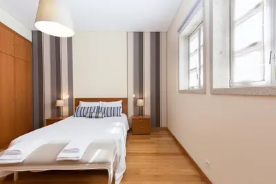 a bedroom with a large bed and two windows at OPO 52 in Porto