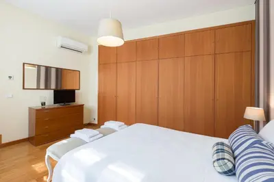 a bedroom with a white bed and wooden cabinets at OPO 52 in Porto