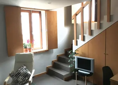 a living room with a staircase and a television at Casa do Bairro 2 in Porto
