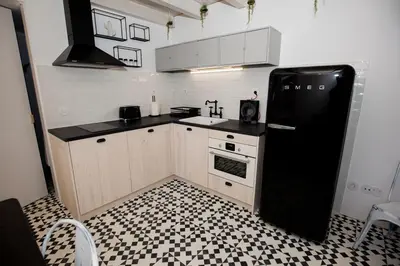 a kitchen with a black refrigerator and a stove at GET a Cactus and Books studio in Porto