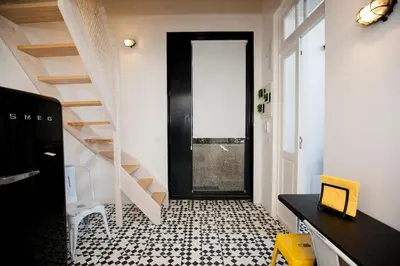 a hallway with a black door and a black and white floor at GET a Cactus and Books studio in Porto