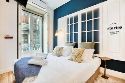 a bedroom with a large bed with blue walls at Janelas de São Bento by Porto City Hosts in Porto