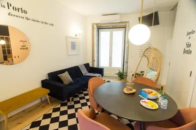 a living room with a table and chairs and a couch at Janelas de São Bento by Porto City Hosts in Porto