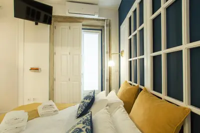 a bedroom with a white bed with pillows at Janelas de São Bento by Porto City Hosts in Porto