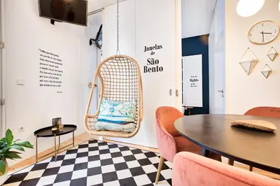 a room with a rattan chair and a table at Janelas de São Bento by Porto City Hosts in Porto