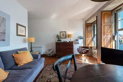 a living room with a blue couch and a table at Porto Premium River View I in Porto