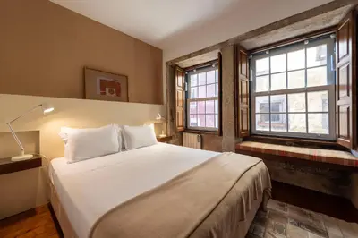 a bedroom with a large bed and two windows at Porto Premium River View I in Porto