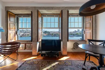 a living room with a flat screen tv and windows at Porto Premium River View I in Porto