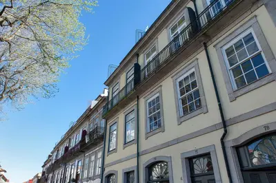 a large building with windows on a street at Sunny view to the Tower in Porto