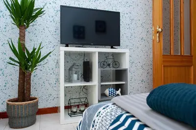 a television on a white cabinet in a bedroom at Sunny view to the Tower in Porto