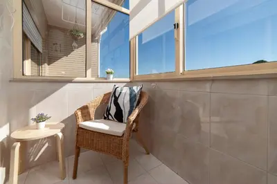 a room with a chair and a table and window at Sunny view to the Tower in Porto