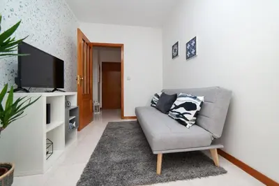 a living room with a couch and a flat screen tv at Sunny view to the Tower in Porto