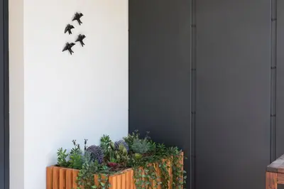 a planter with plants and butterflies on a wall at LovelyStay - Downtown Balcony Apartment with Free Parking in Porto