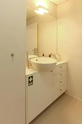 a white bathroom with a sink and a mirror at Villa D'Ouro in Porto