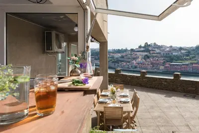 a balcony with tables and chairs and a view of a city at Villa D'Ouro in Porto