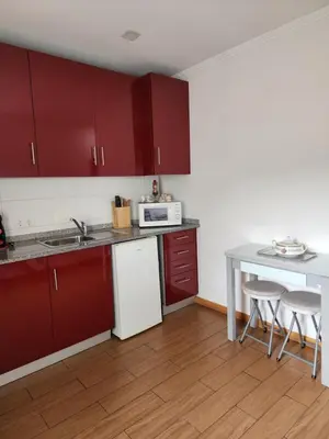 a kitchen with red cabinets and a table and chairs at D'OURO DOM LUÍS By LW in Vila Nova de Gaia