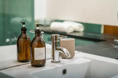two bottles ofodorizers sitting on a bathroom sink at Firmeza388 Charming Flats - Comfort & Privacy with 2 Bedrooms in Porto