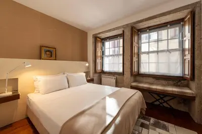 a bedroom with a large white bed and windows at Porto Premium River View II in Porto