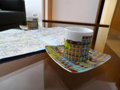 a coffee cup sitting on a plate on a table at Porto City Experience in Porto