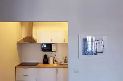 a small kitchen with white cabinets and a microwave at Panorama Apartments Ribeira Gaia in Vila Nova de Gaia