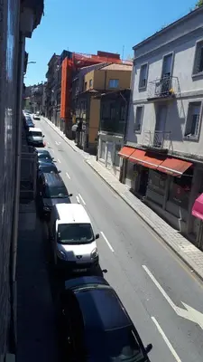 a row of cars parked on the side of a street at TMB (Train / Metro& Bus ) Oporto Station House in Porto