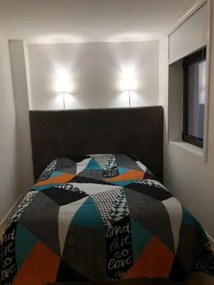 a bedroom with a bed with a colorful quilt on it at TMB (Train / Metro& Bus ) Oporto Station House in Porto
