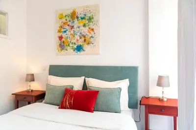 a bedroom with a bed with red and green pillows at River Flat IV - Heart of Porto in Porto