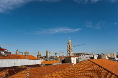 a view of a city with roofs and a clock tower at Baixa24 •P3R• Super estúdio no centro histórico in Porto
