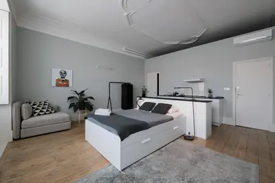 a white bedroom with a bed and a couch at Baixa24 •P2R• Bright Apt in Vibrant Downtown in Porto